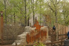 Smoke from train rises in background around track behind the sign for Outlaw Run Smoke from train rises in background around track behind the sign for Outlaw Run - Silver Dollar City - Outlaw Run - A New Roller Coaster that is as Exciting as it Seems!