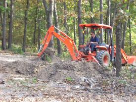 Click to enlarge image  - Breaking ground on the Earth Shelter House - It is official.. there is a hole!!