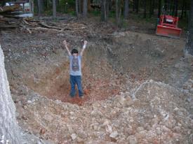 Click to enlarge image - Breaking ground on the Earth Shelter House - It is official.. there is a hole!!