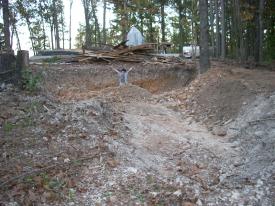 Click to enlarge image  - Breaking ground on the Earth Shelter House - It is official.. there is a hole!!