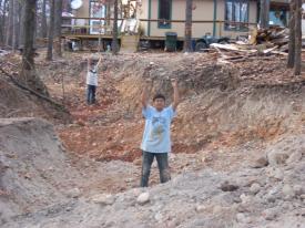 Click to enlarge image  - Breaking ground on the Earth Shelter House - It is official.. there is a hole!!